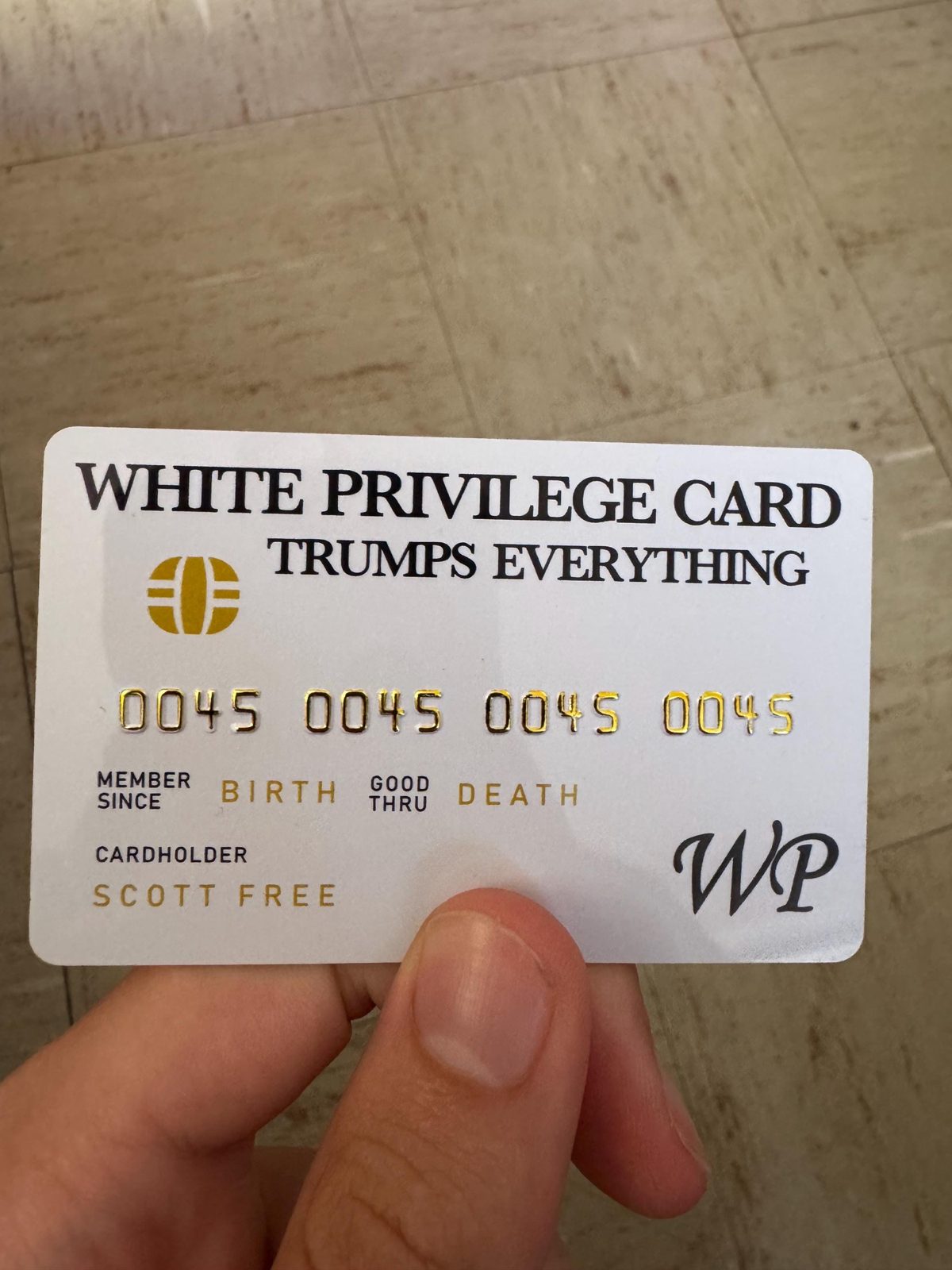 White Privilege Card held in hand, credit card size